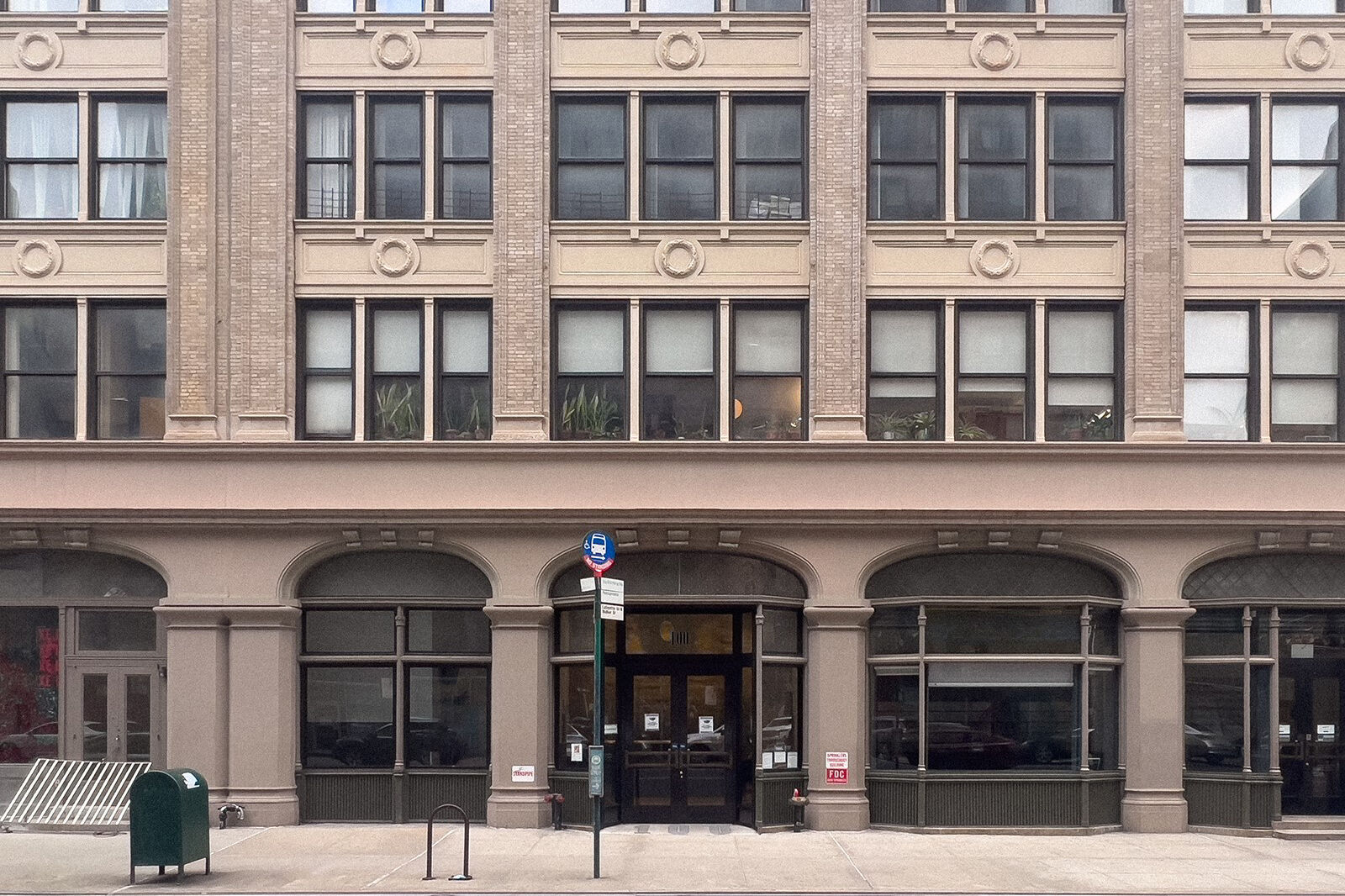 The facade of a building with brick and many windows in New York City. 