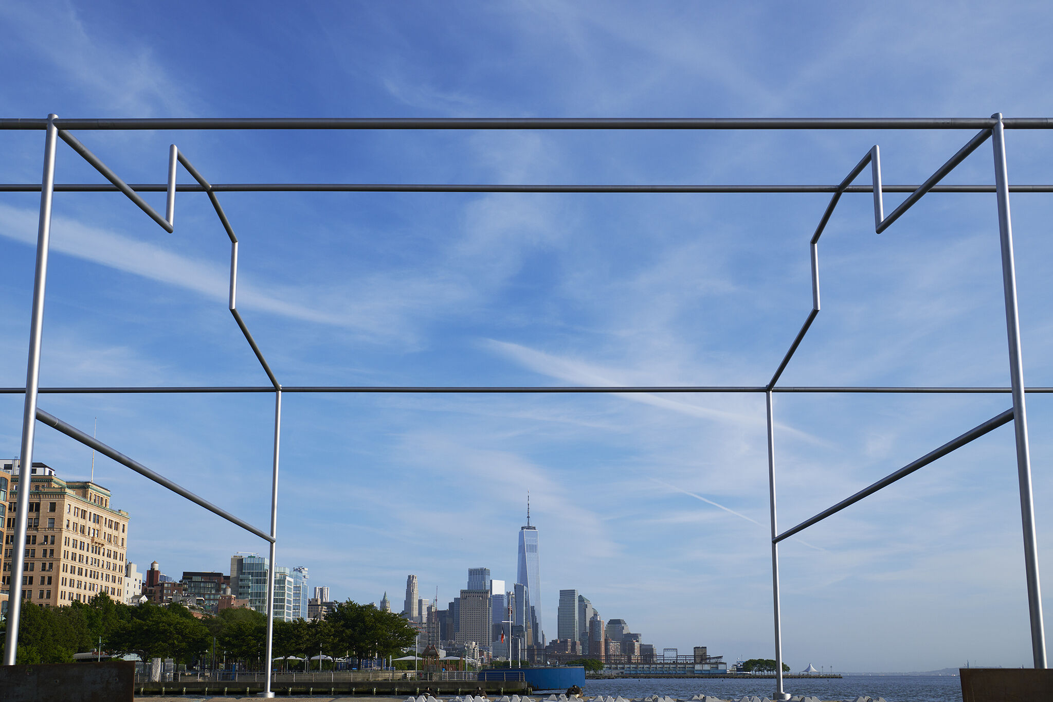 Close-up view of Day's End steel sculpture framing the Manhattan skyline in the background.