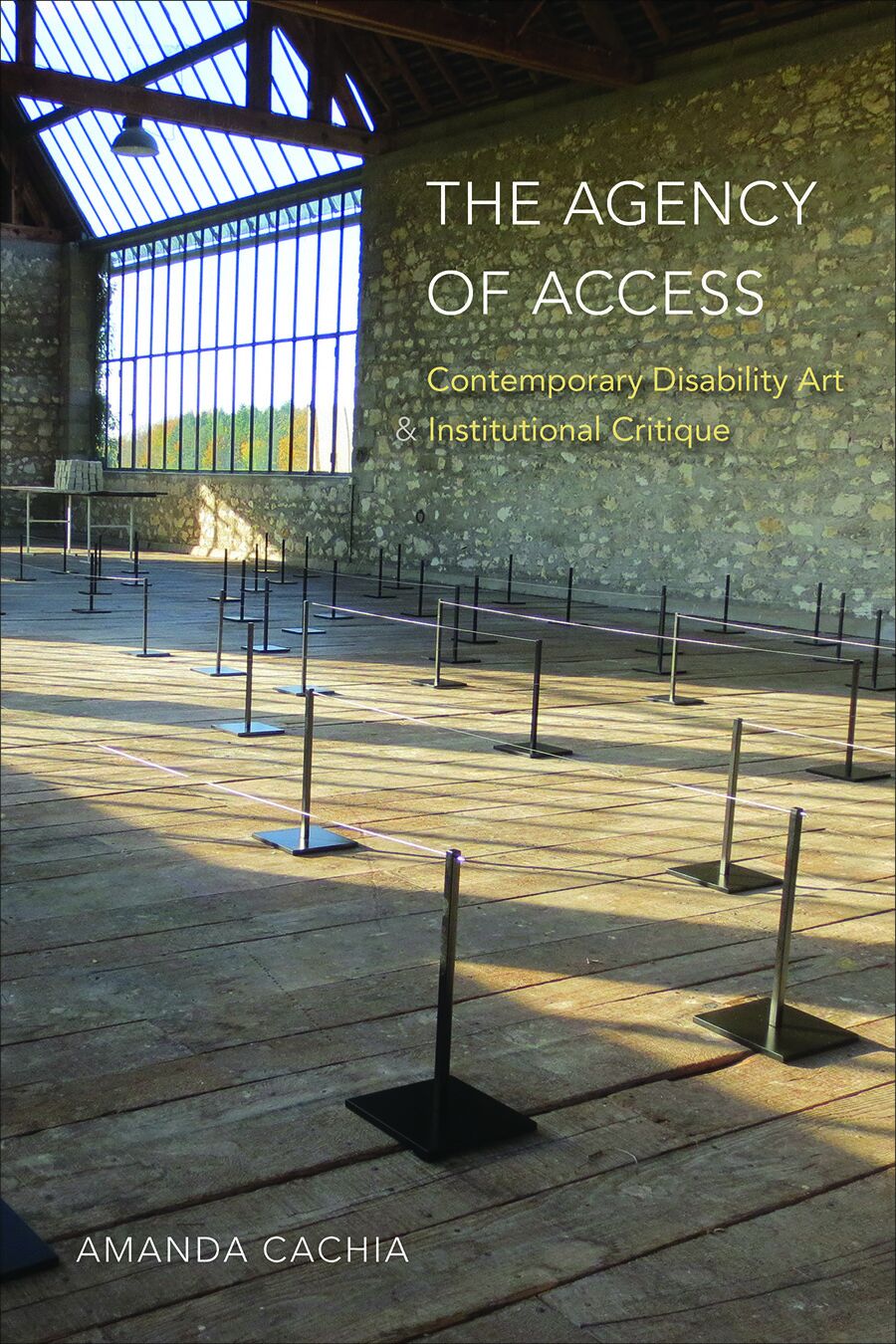  A book cover with a photograph of an open space filled with rows of stanchions. A large window in the corner casts natural light across the room. At the top left corner is the book’s title: The Agency of Access: Contemporary Disability Art & Institutional Critique. At the bottom right corner is the author’s name, Amanda Cachia.
