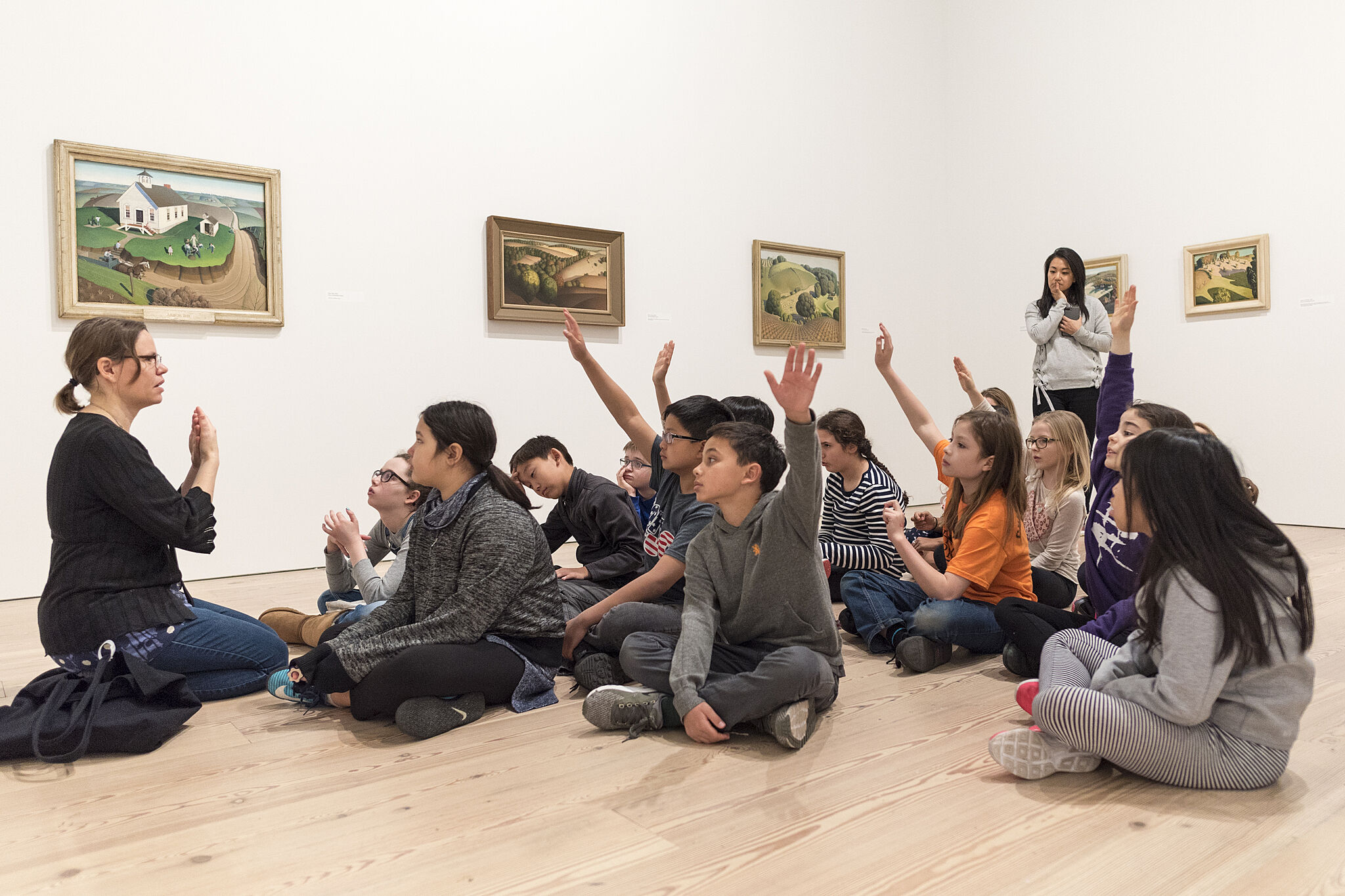 Children sitting on the floor in a gallery.