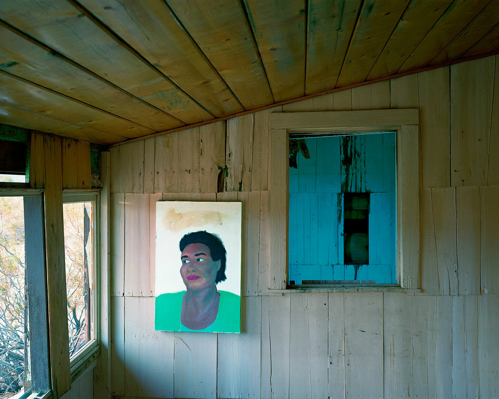 Photograph of portrait hanging on an abandoned building wall