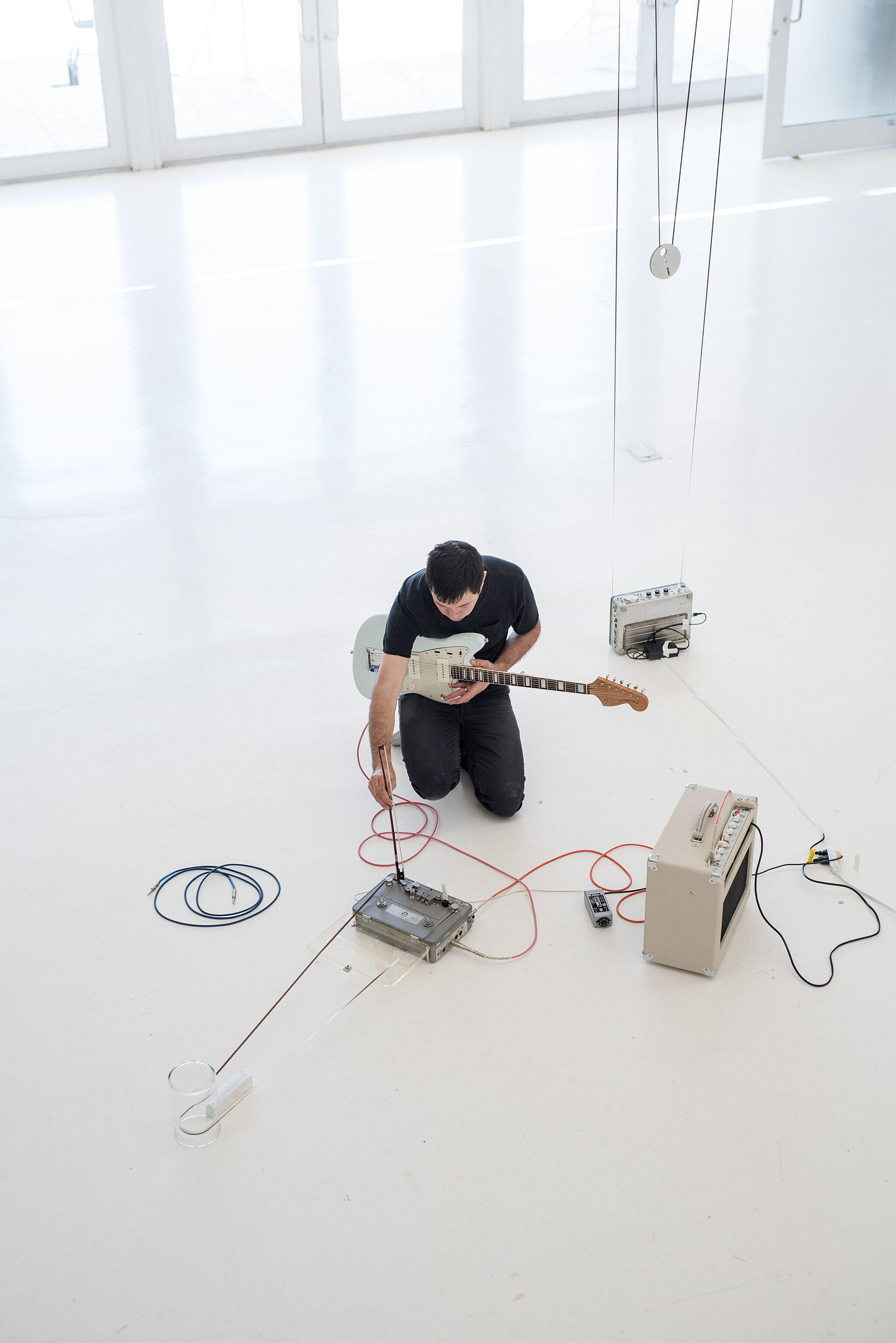 An aerial view of an artist generating a sound installation with a guitar.