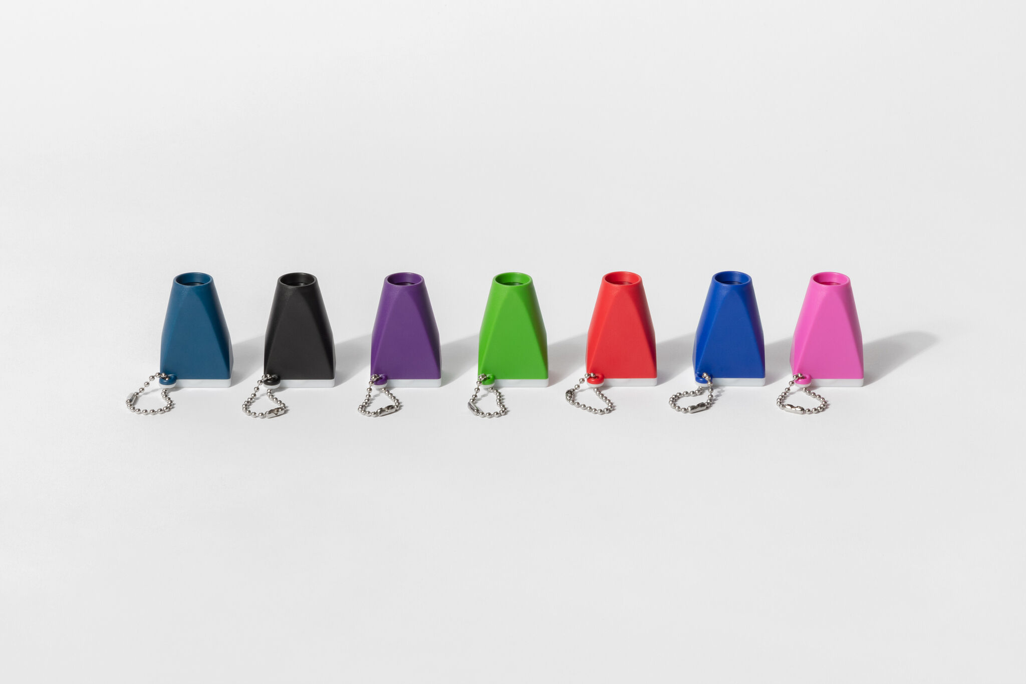 Small, multicolored magnifying keychains, arranged in a straight line against a gray background.