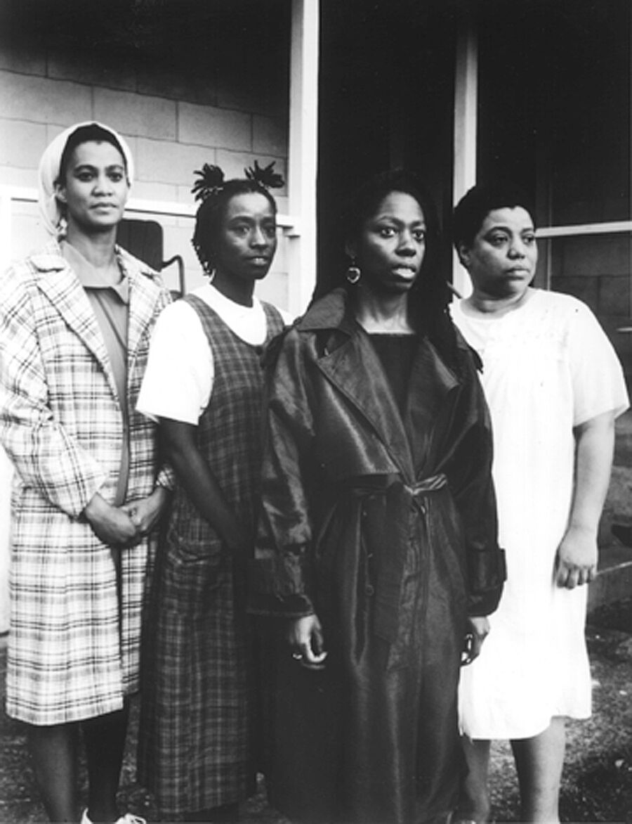 A film still of 4 women staring into the distance.